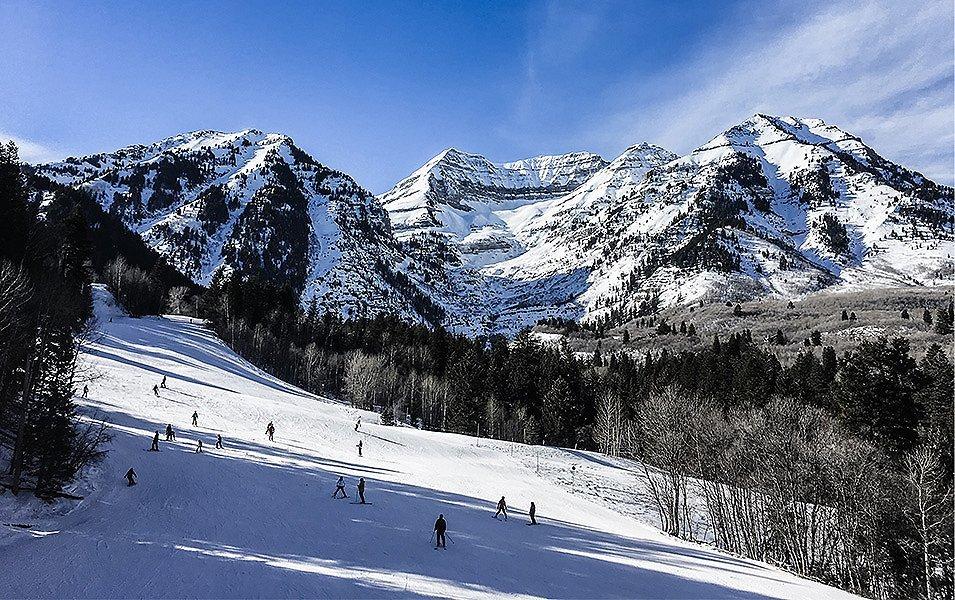 More than a dozen skiers traverse a snow-covered slope at Sundance Mountain Resort, Utah, which is known for its partnership with Wasatch Adaptive Sports.