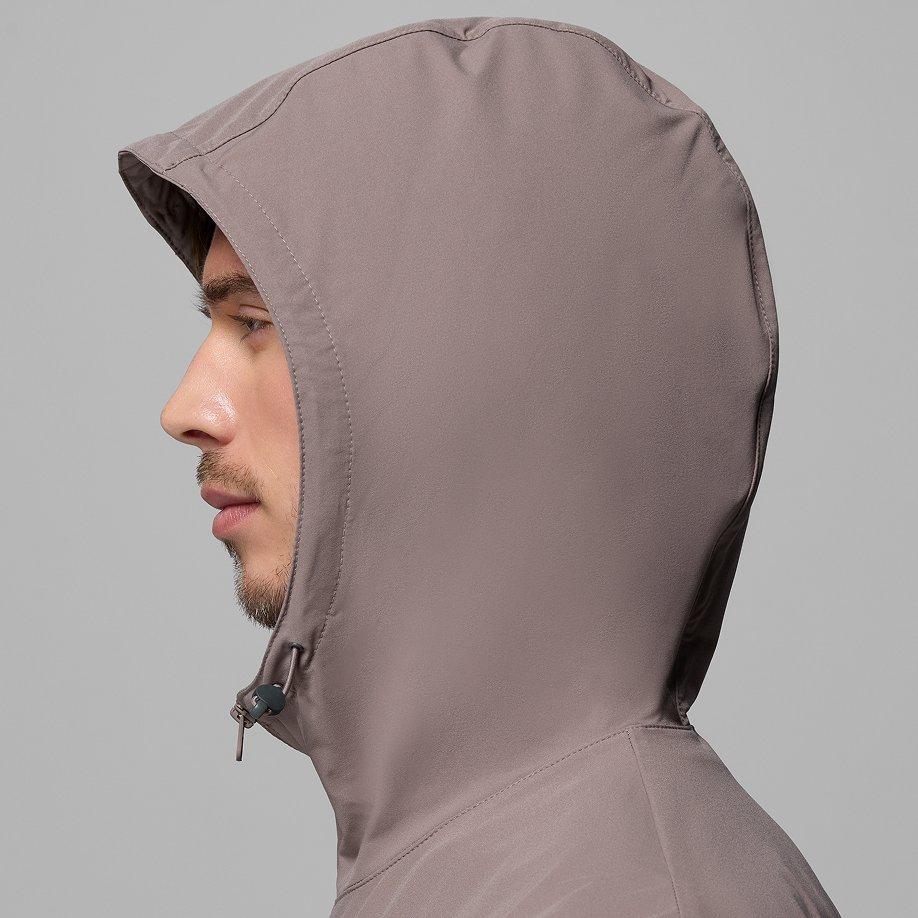 Profile view of a taupe hooded jacket with drawstring closure, showing hood design and fit.