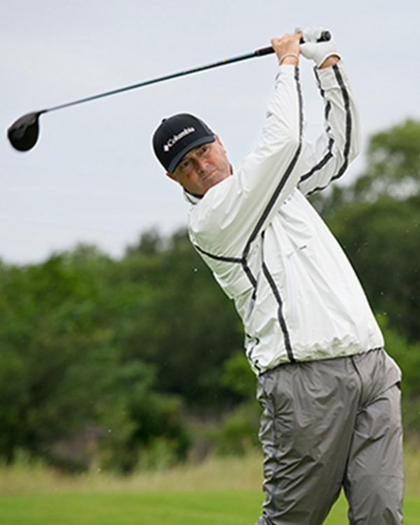 Man swinging a gold club.