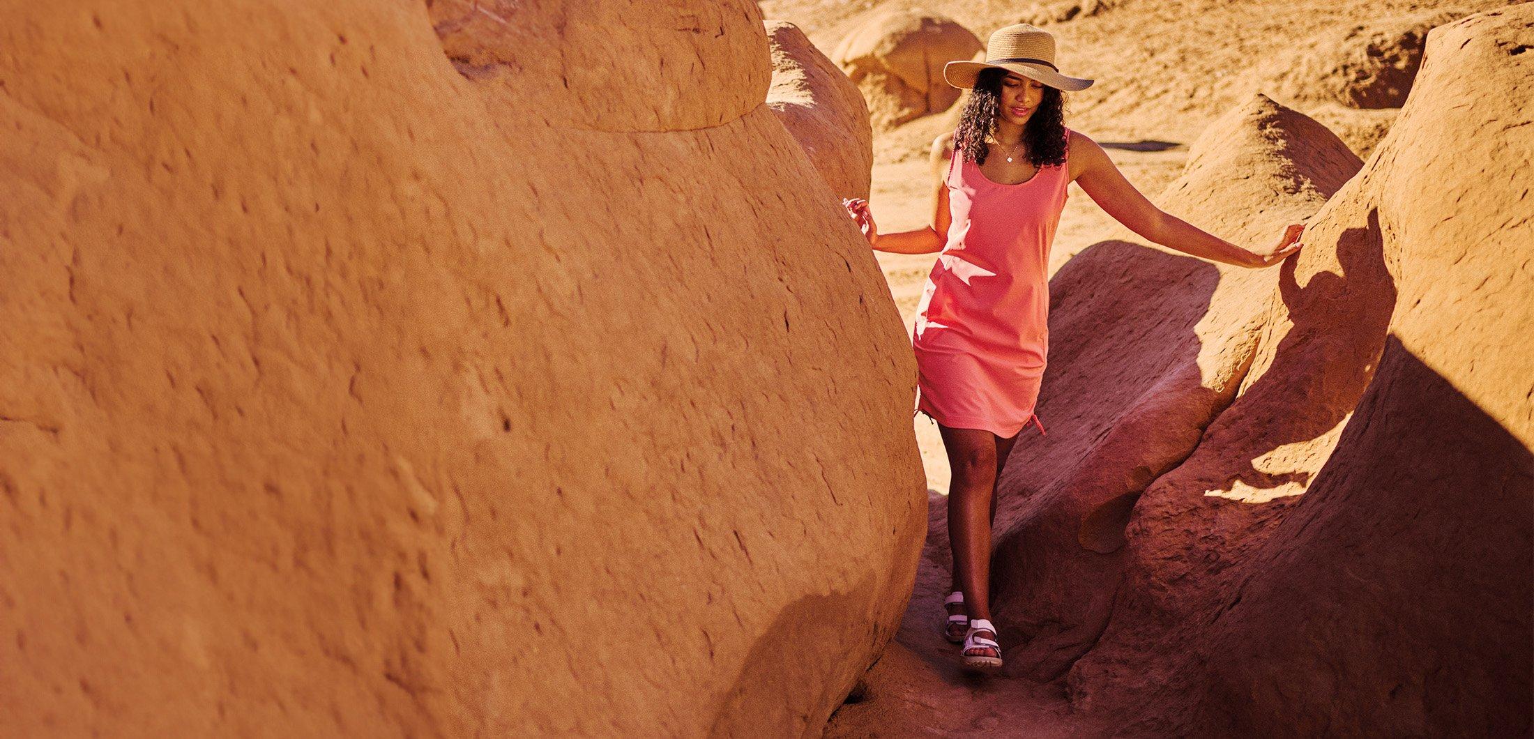 Comfort, Style, Tech over an image of a woman walking through a rocky landscape.