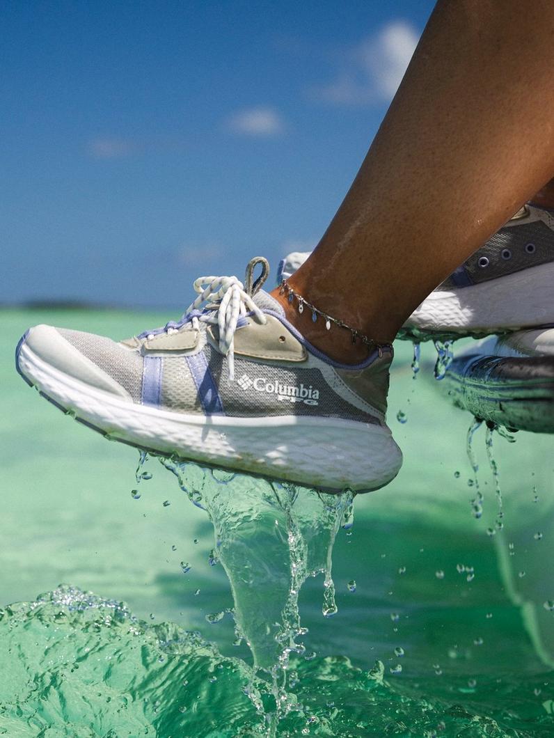 A person stepping from the ocean to a boat in PFG shoes. 
