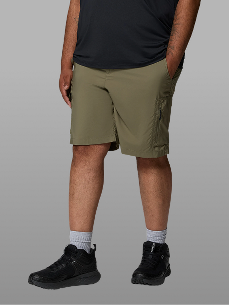 Waist-down image of a man wearing green shorts and sneakers.