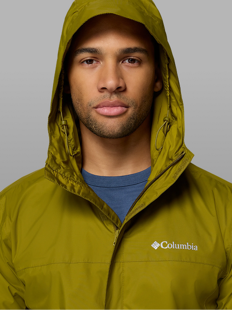 A man wearing a green rain jacket with the hood up.