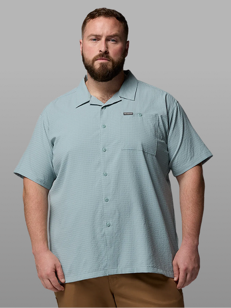 A man wearing a blue short-sleeve button-up.