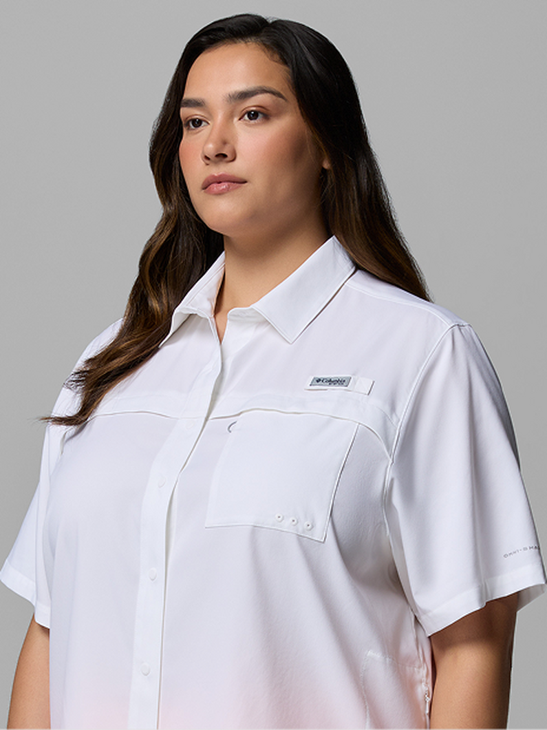 A woman wearing a white short-sleeve button-up.