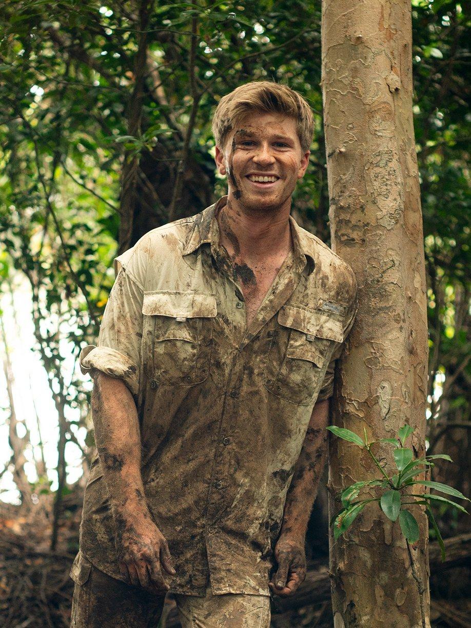 Robert Irwin leaning against a tree.