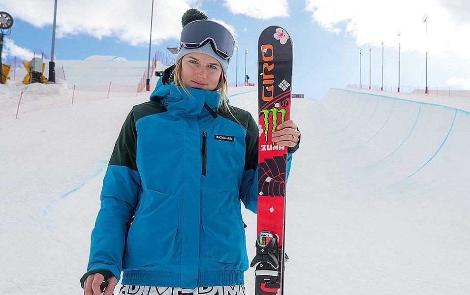 Columbia Sportswear Ski Ambassador and Olympian, Cassie Sharpe, holds her skis while wearing a blue Columbia Parka.