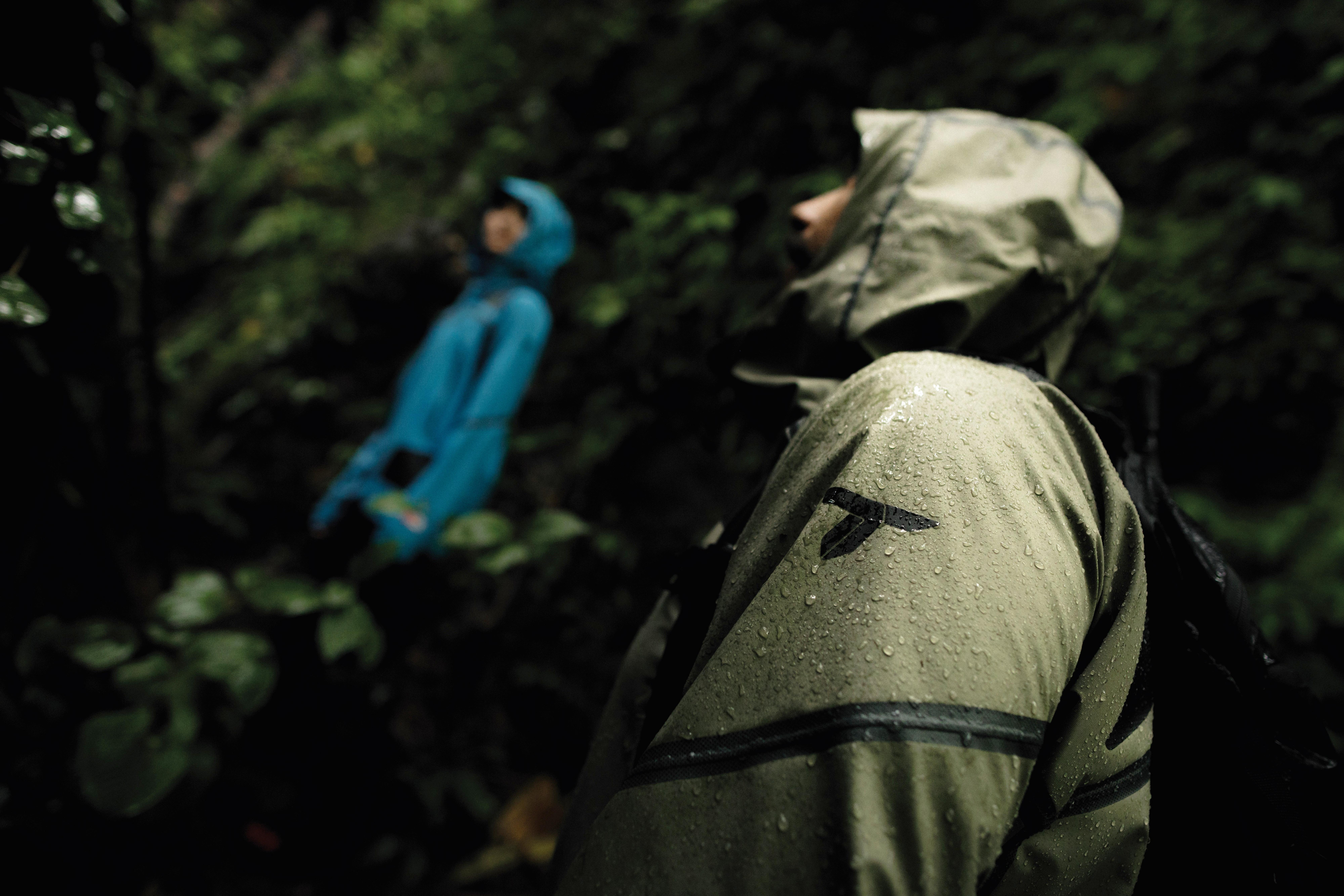 Close-up of a person's green rain jacket with the Titanium logo on the sleeve.