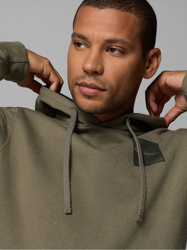 A man wearing a green long-sleeve flannel with text: Shirts