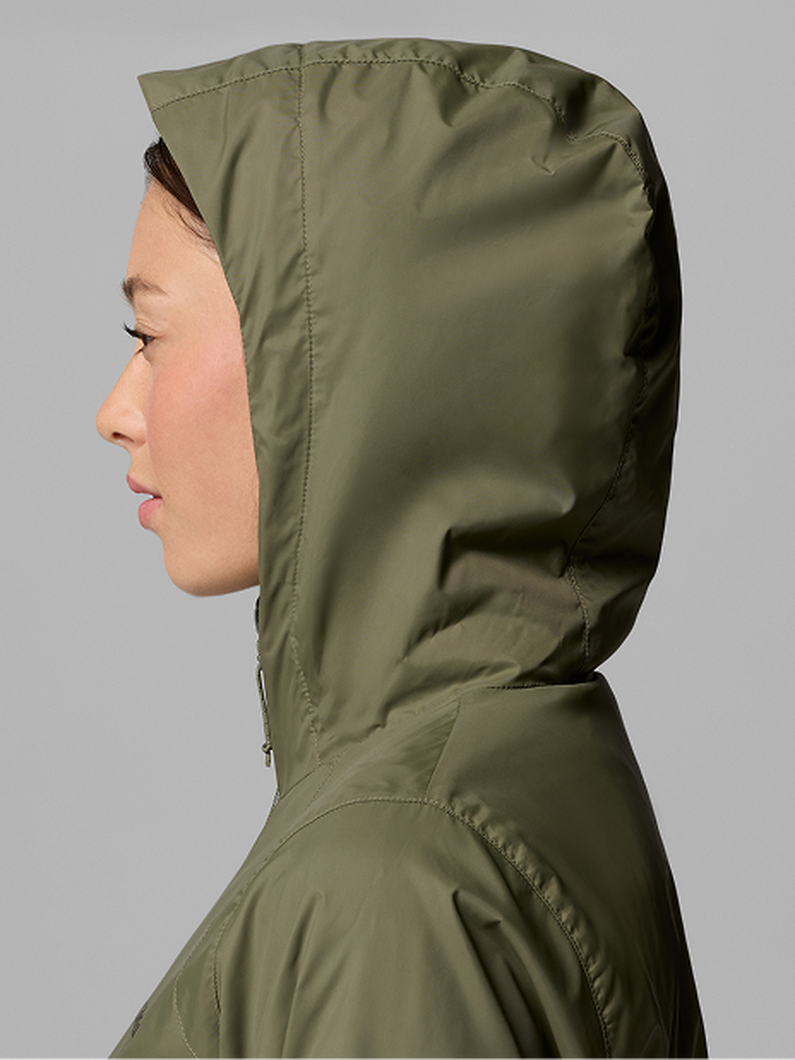 A woman wearing a brown puffer jacket with text: Jackets