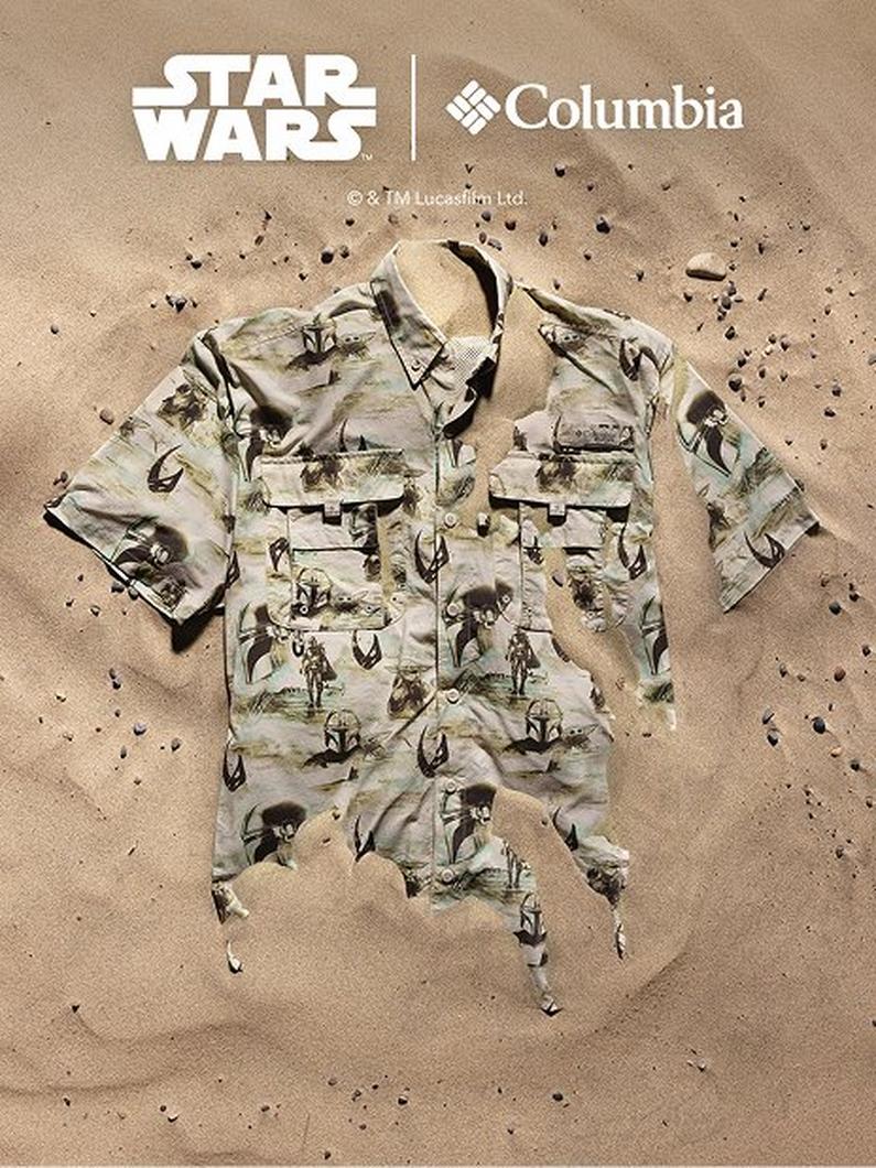 Beige button-up shirt with multiple chest pockets featuring an all-over desert scene print laid flat on sand.