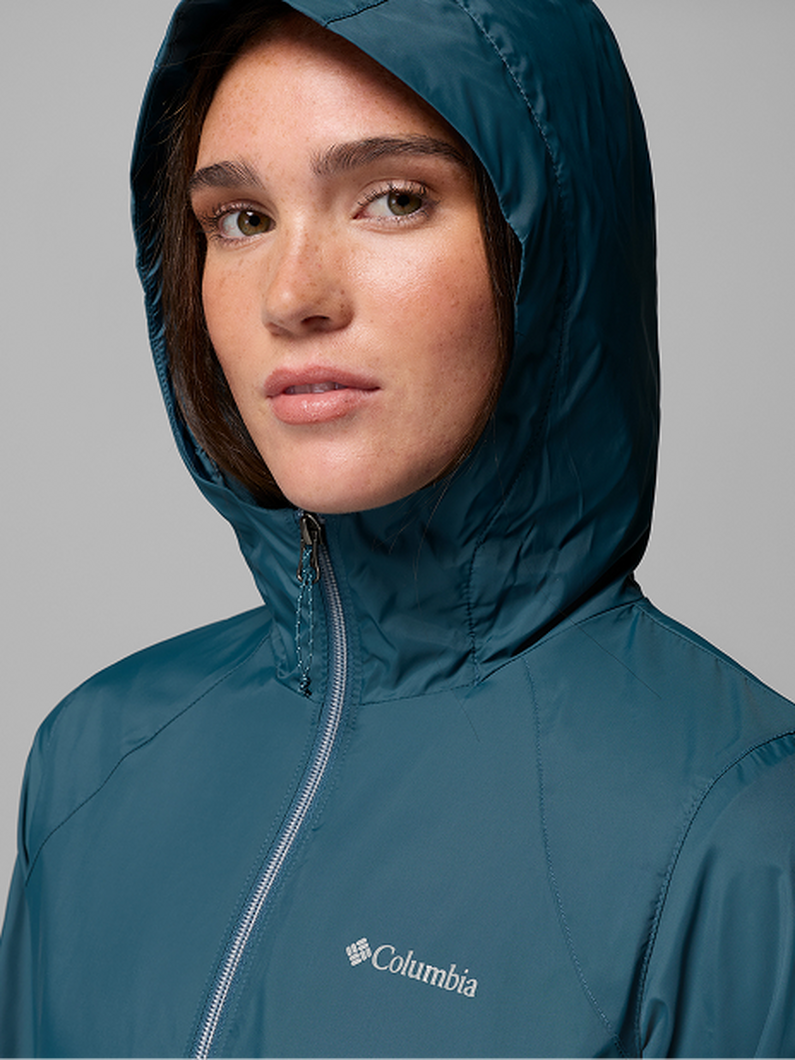 A woman wearing a brown puffer jacket with text: Jackets