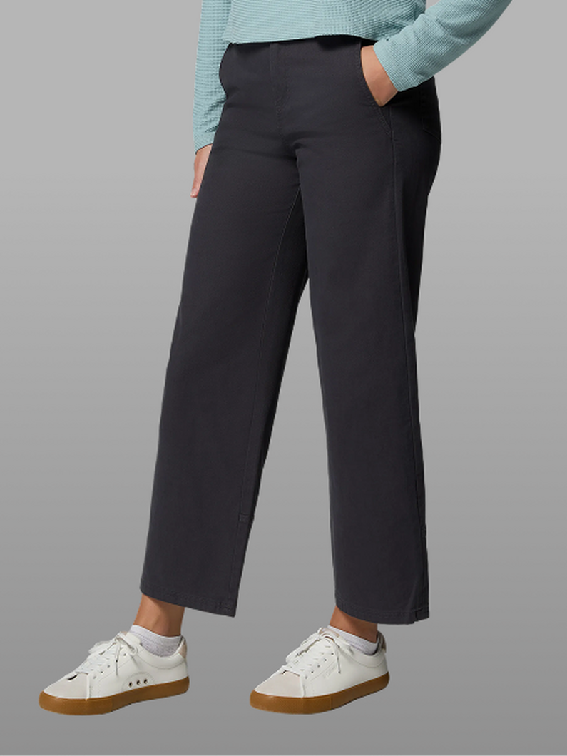 Waist-down image of a woman wearing a black pants and sneakers.