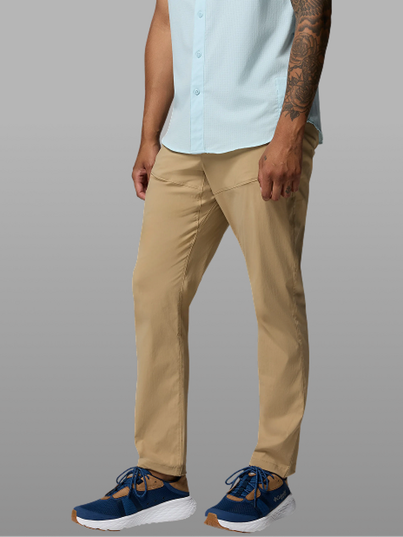 Waist-down image of a man wearing tan pants and sneakers.