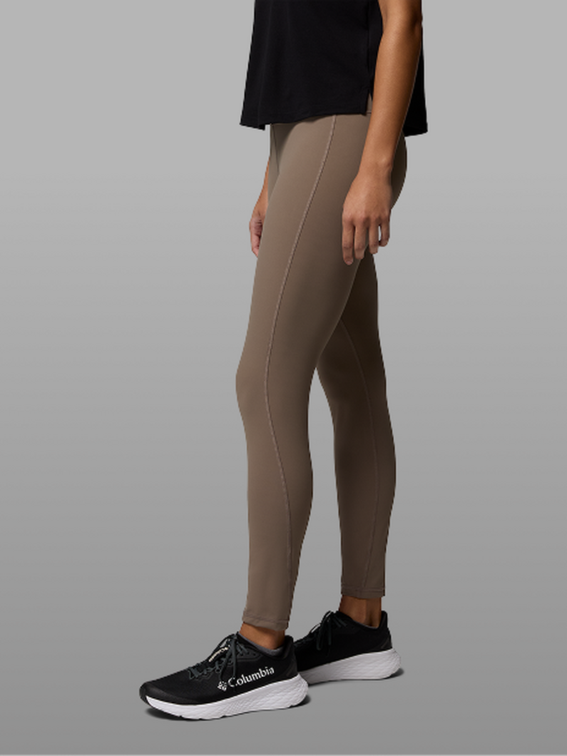 Waist-down image of a woman wearing grey leggings and sneakers.