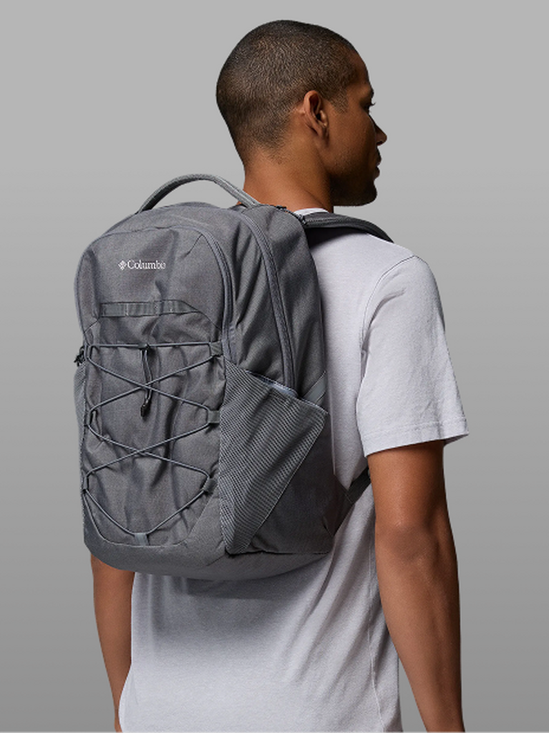 A man facing away from the camera, wearing a grey backpack.