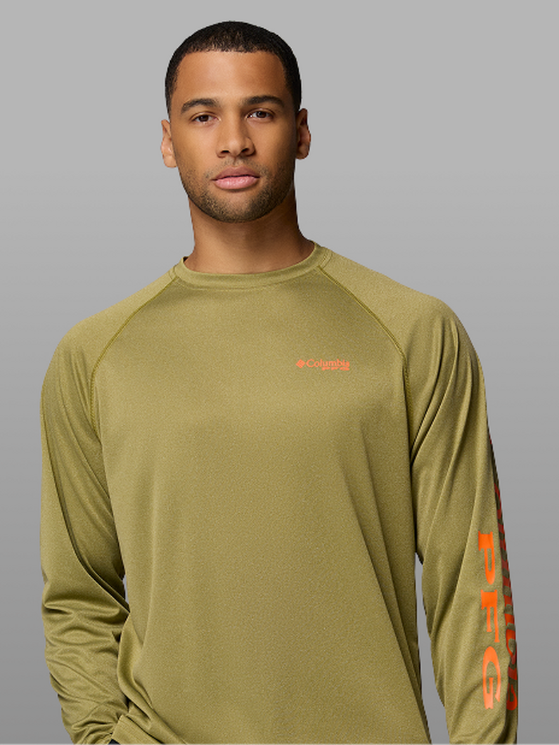 A man wearing a green long-sleeve shirt with the PFG logo on the sleeve.