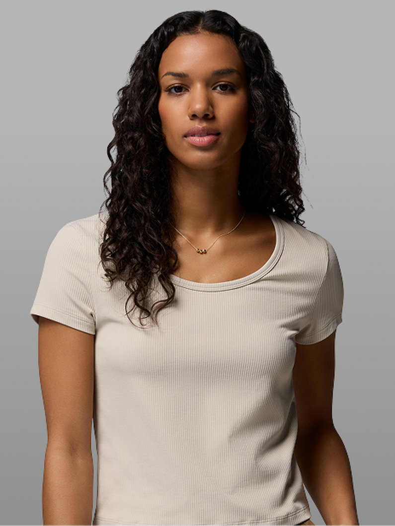 A woman wearing a white short-sleeve shirt.