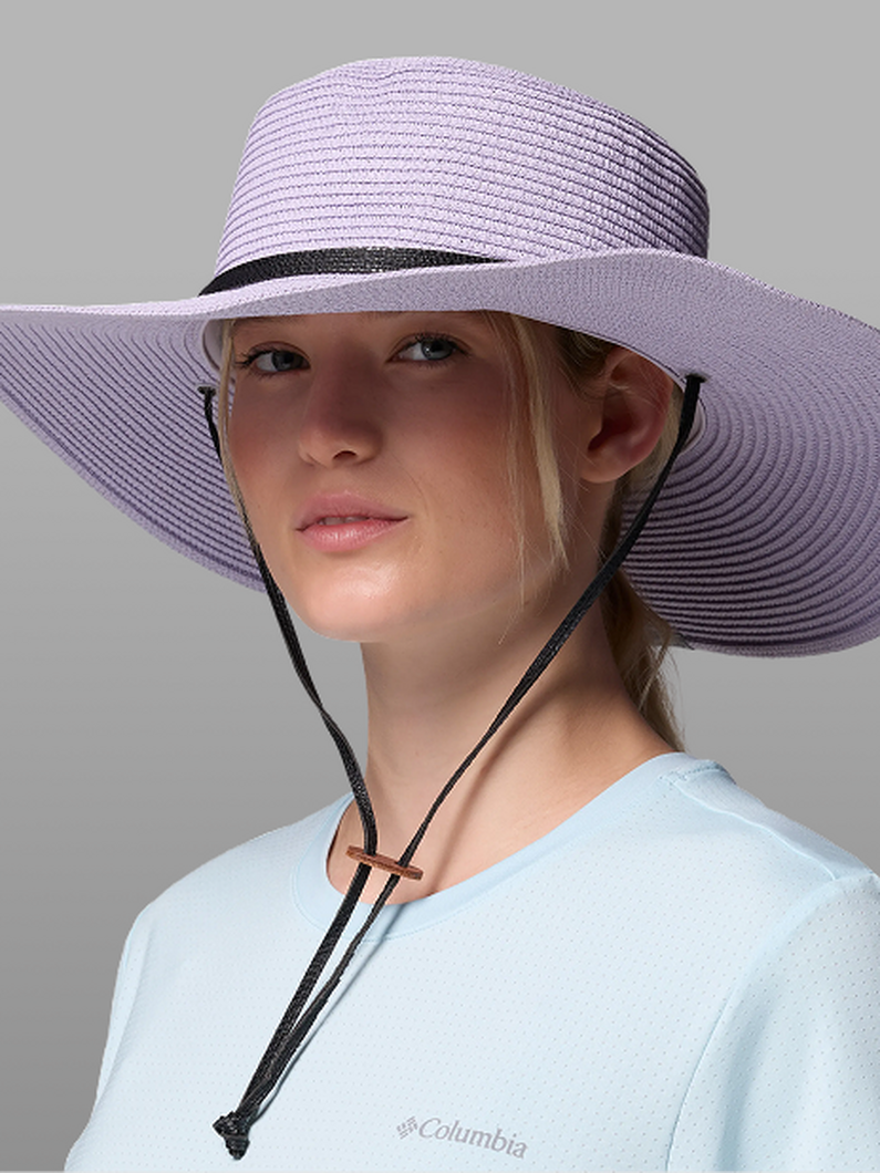 A woman wearing a purple sun hat.