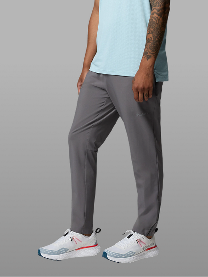 Waist-down image of a man wearing grey pants and sneakers.