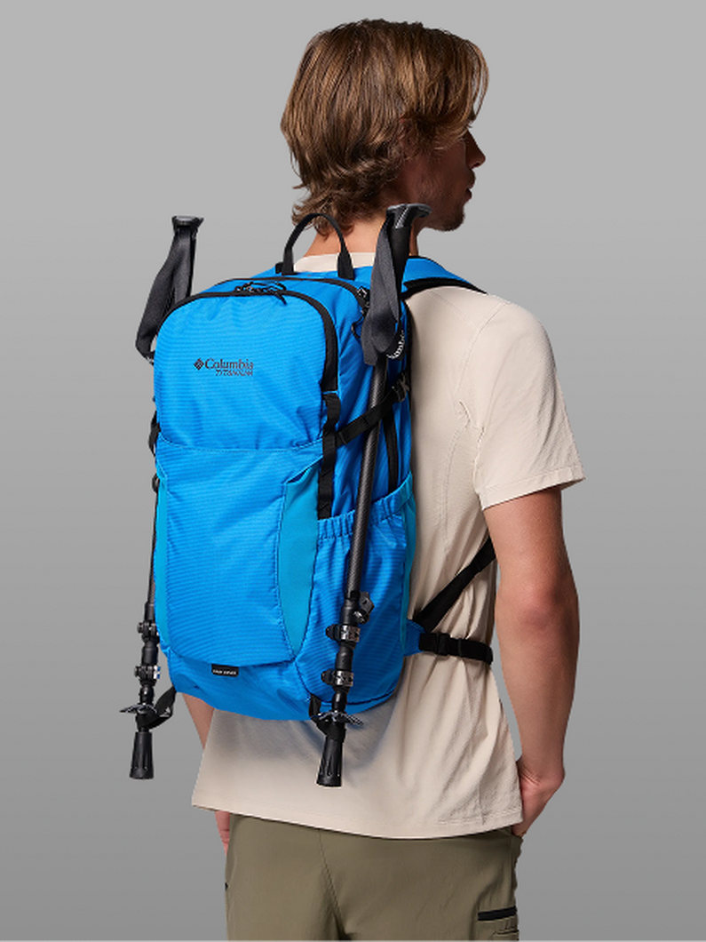 A man facing away from the camera wearing a blue backpack.