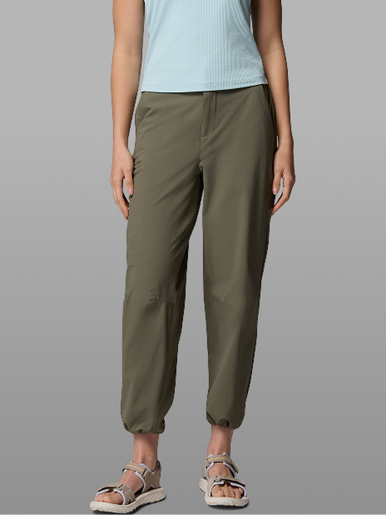 Waist-down image of a woman wearing green pants and sandals.
