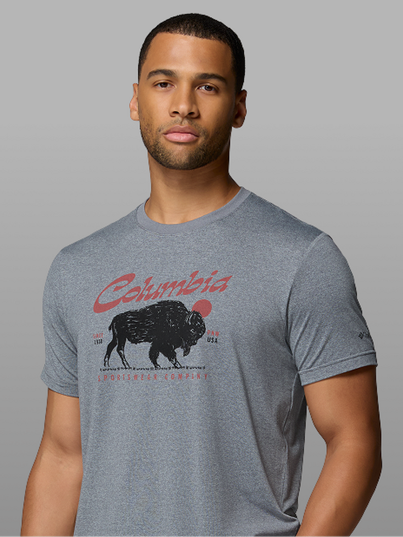 A man wearing a grey graphic tee with a buffalo on it.