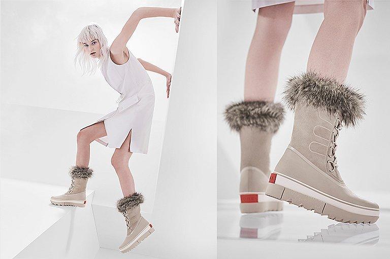Woman posing wearing pair of Joan NEXT boots with futuristic background