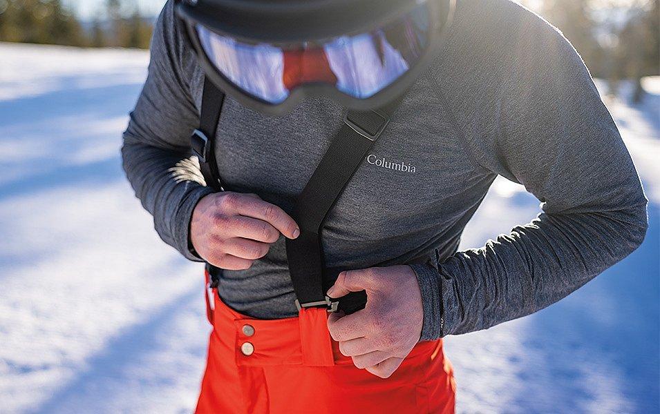 This skier double-checks the suspenders on his bibs before heading down the slopes.
