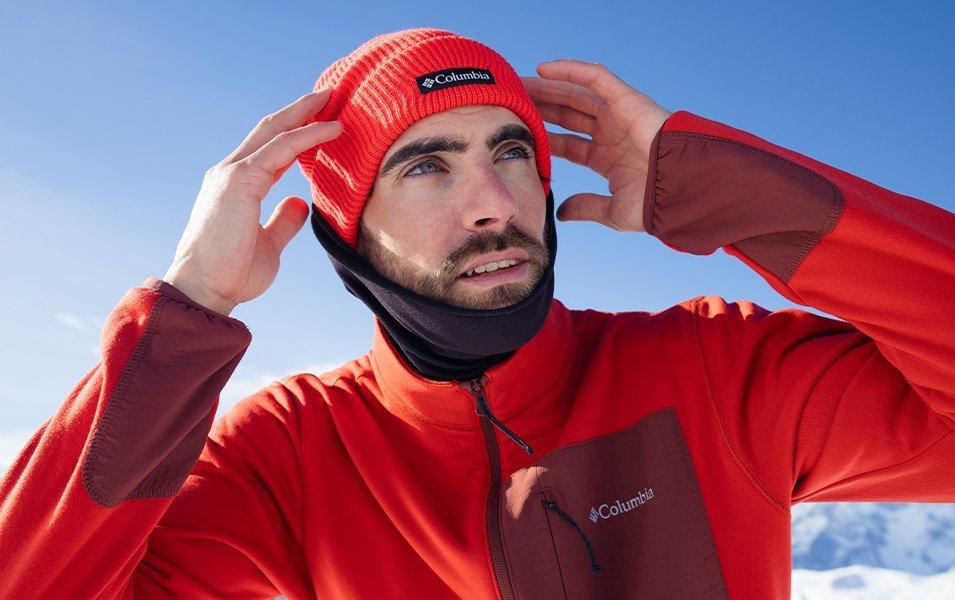 A man checks that his warm beanie is covering his head and that his neck gaiter is snugged up tight around his ears.