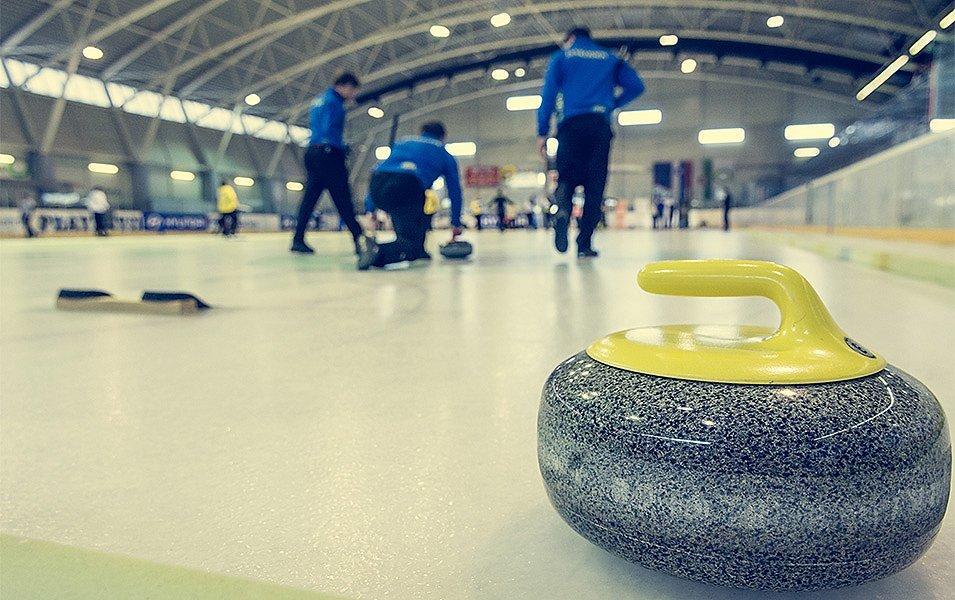 Curlers in an indoor rink work together for the next point. 