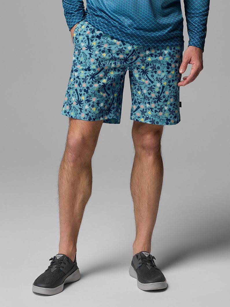 Men's shorts in teal with tropical floral print worn with coordinating patterned long-sleeve top.