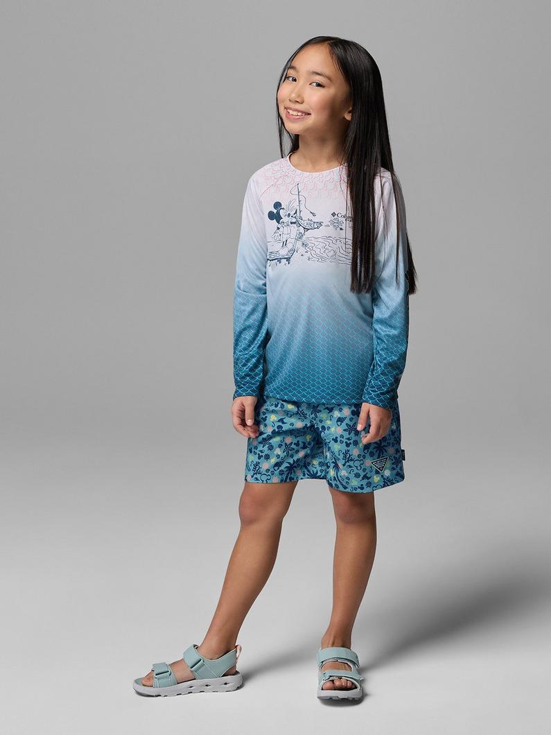 Girl wearing long-sleeve ombre shirt with graphic and patterned shorts, paired with sport sandals.