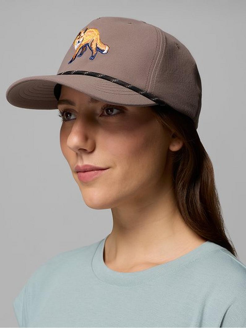 Woman wearing a brown trucker-style cap with an embroidered fox design on the front panel.