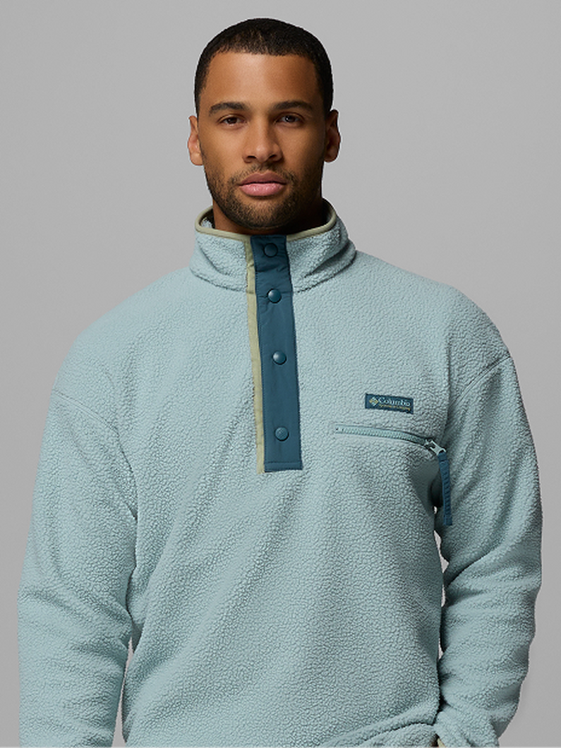 Man wearing light blue fleece pullover with snap button placket and chest pocket.