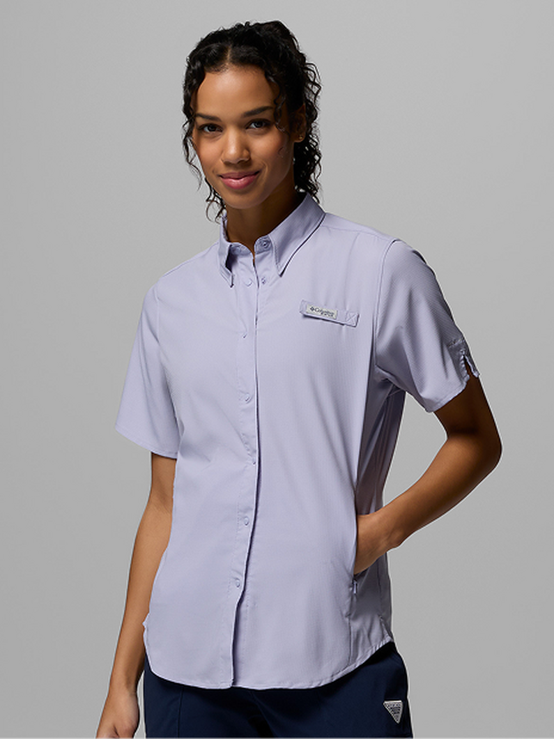 Woman wearing a light purple short-sleeve button-up shirt with chest pocket and side panel details.