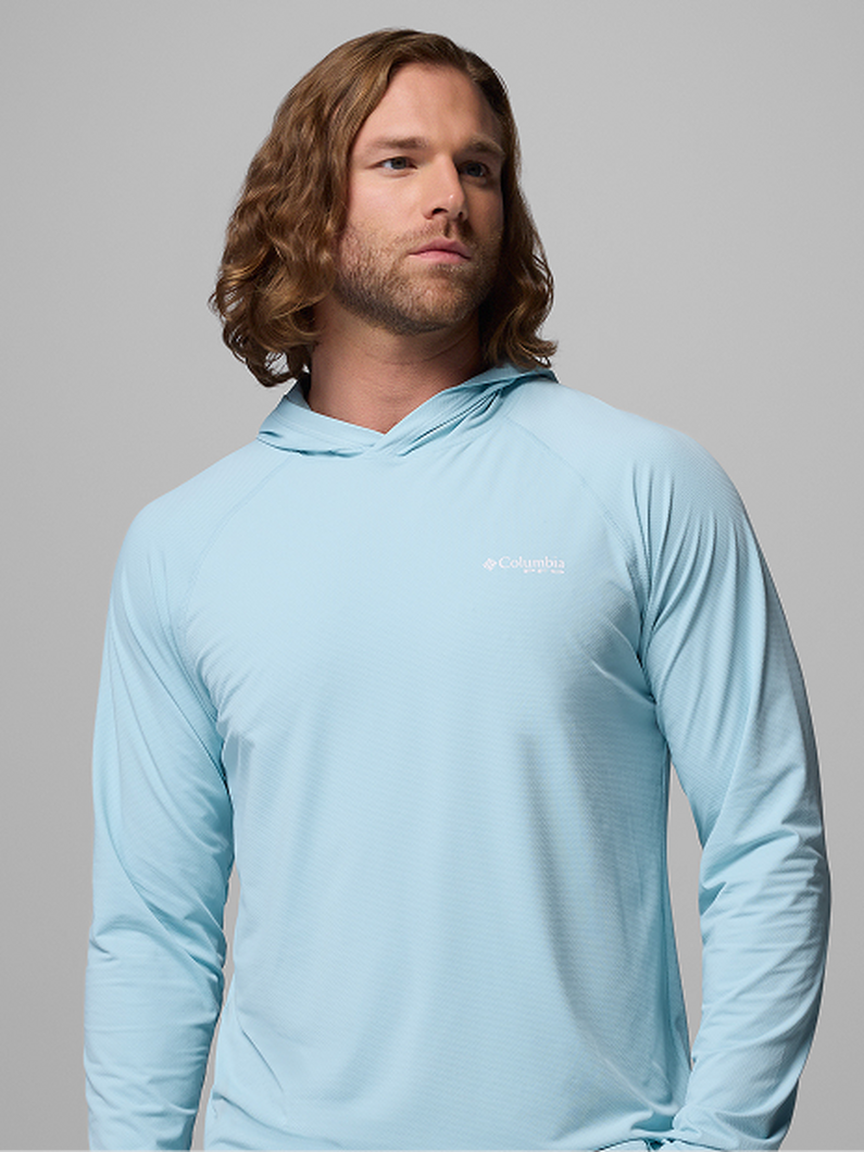 Man wearing light blue long-sleeve hooded performance shirt looking to the side.