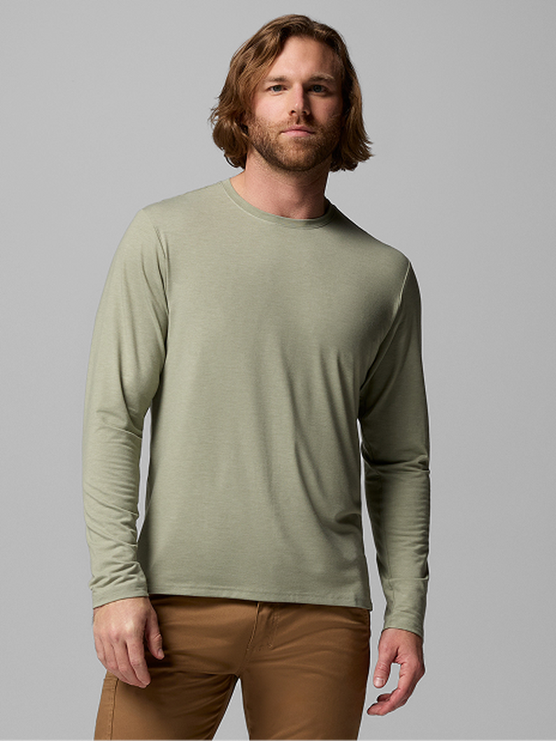 Man wearing sage green long-sleeve crew neck shirt with brown pants.
