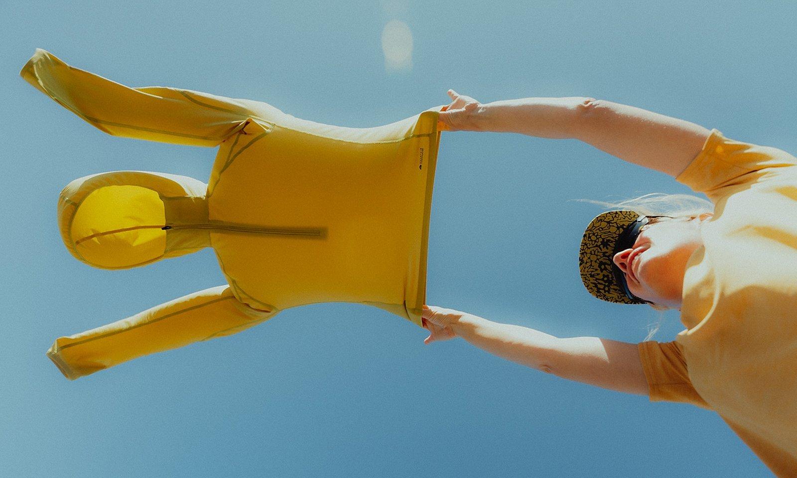 A hiker holds a Sunshield Hoody in the wind.