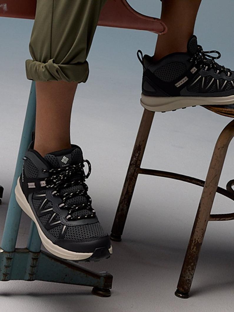 Close-up of boys' sneakers under a desk.