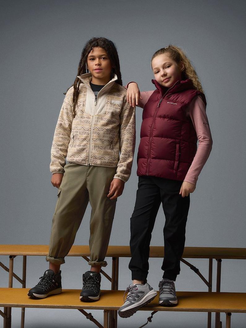 Two kids standing on bleachers.