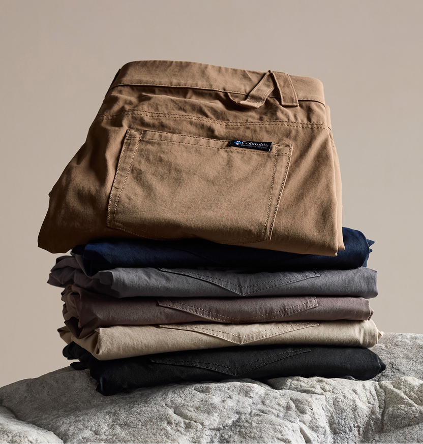 Stack of different colors of folded pants on a rock