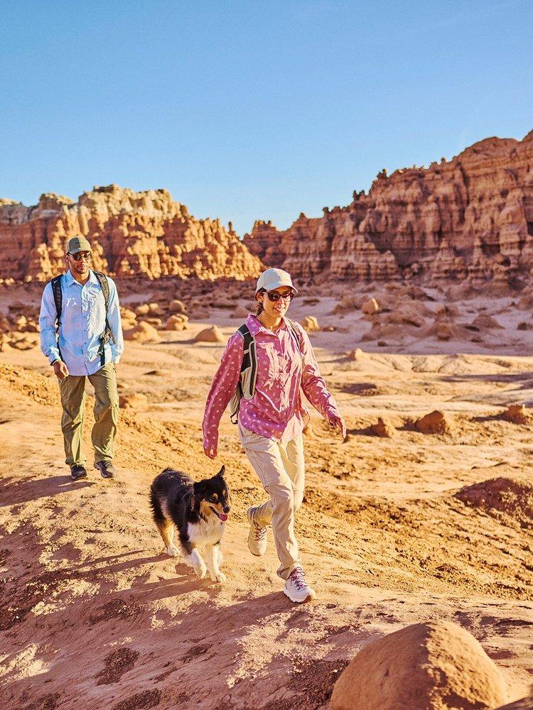 Two people walking on a desert trail.