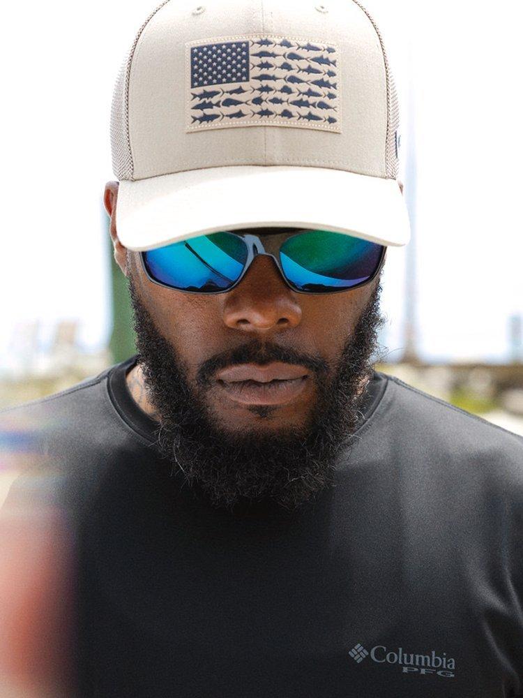 PFG Hat on a man wearing sunglasses and a black shirt.