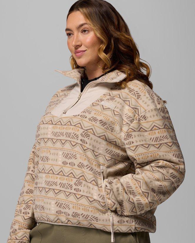 A woman wearing a tan Fleece half-zip with a geometric pattern.