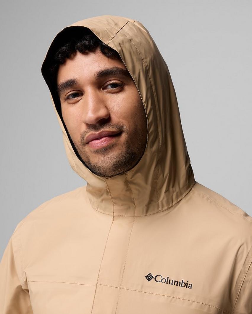 A man wearing a tan jacket with the hood up.