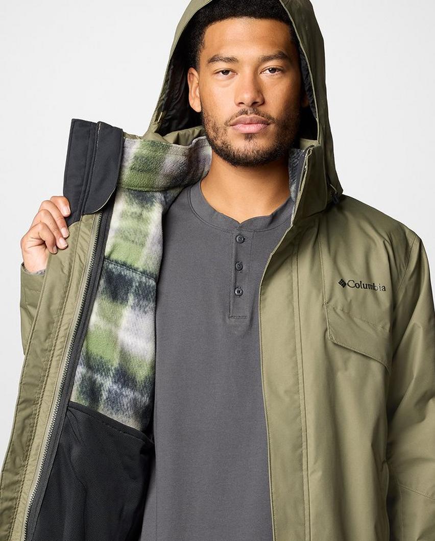 A man opening his green Interchange jacket to reveal the inner layer.