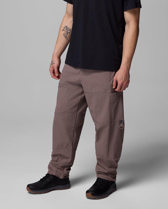 Waist-down image of a man wearing brown pants and sneakers.