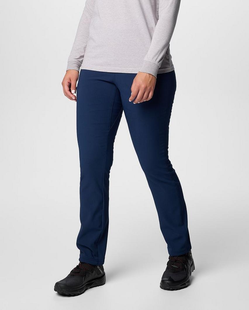 Waist-down image of a woman wearing navy pants and sneakers.