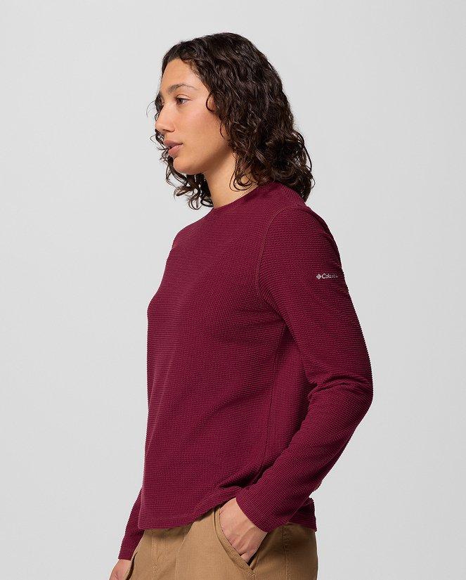 A woman wearing a dark red long-sleeve shirt.
